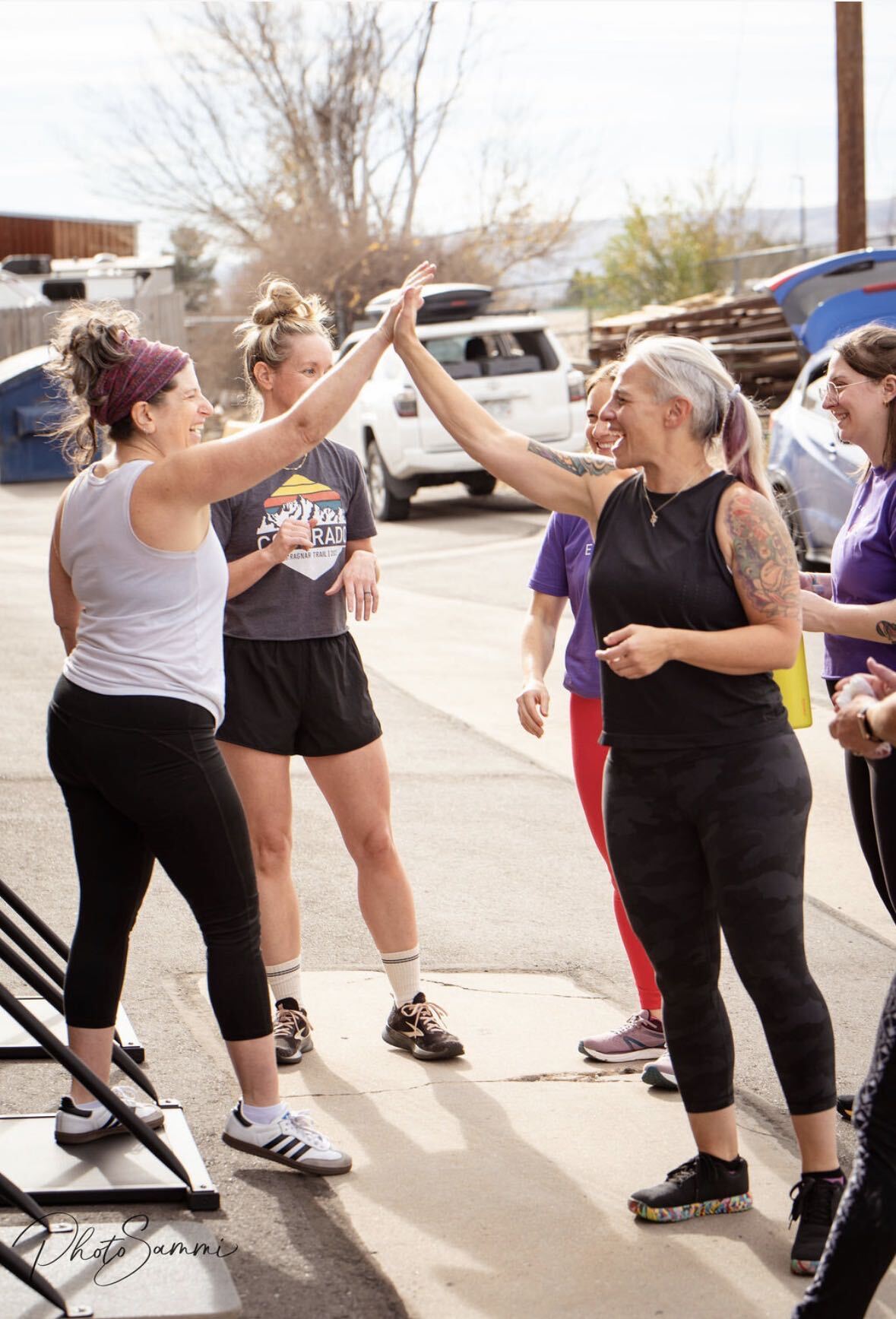 Ethos Colorado members high-fiving after an outdoor group workout