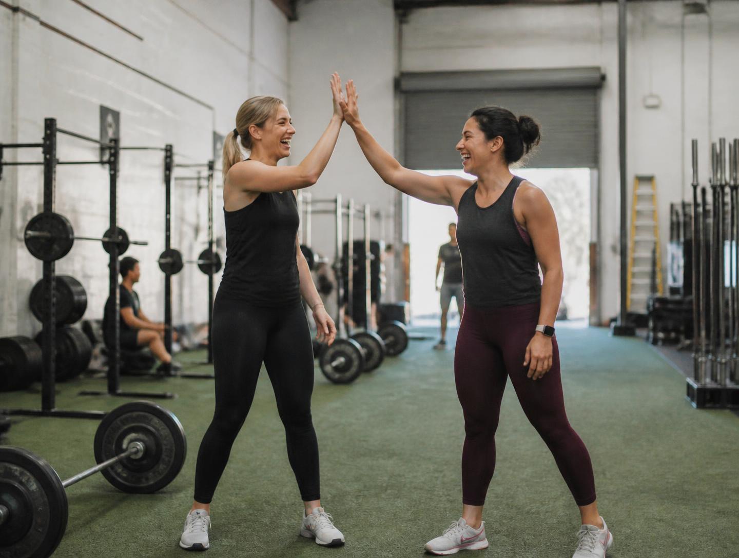 Two women celebrating after a group workout at Ethos Colorado